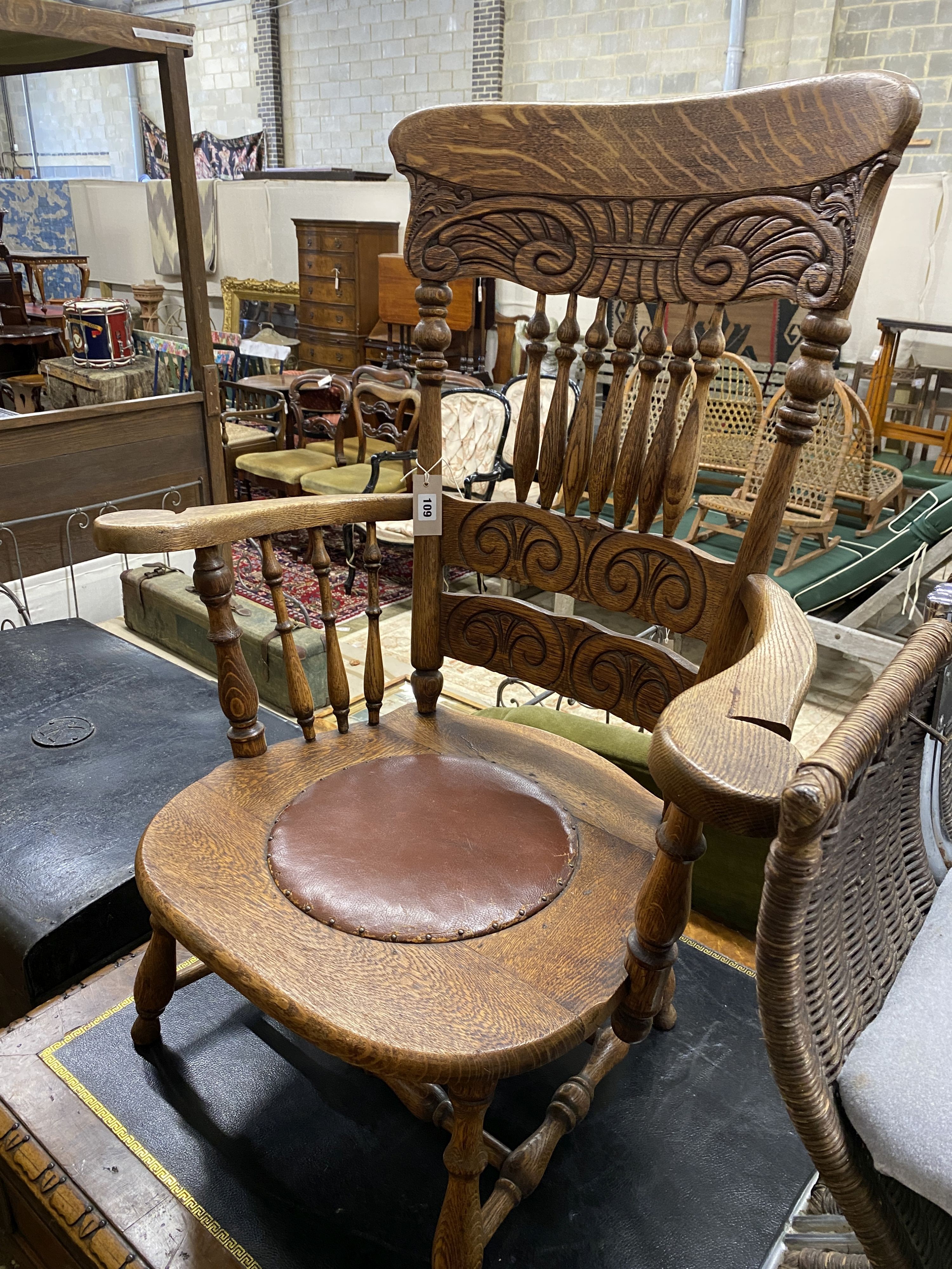 An early 20th century oak low seat elbow chair, width 75cm, depth 48cm, height 97cm